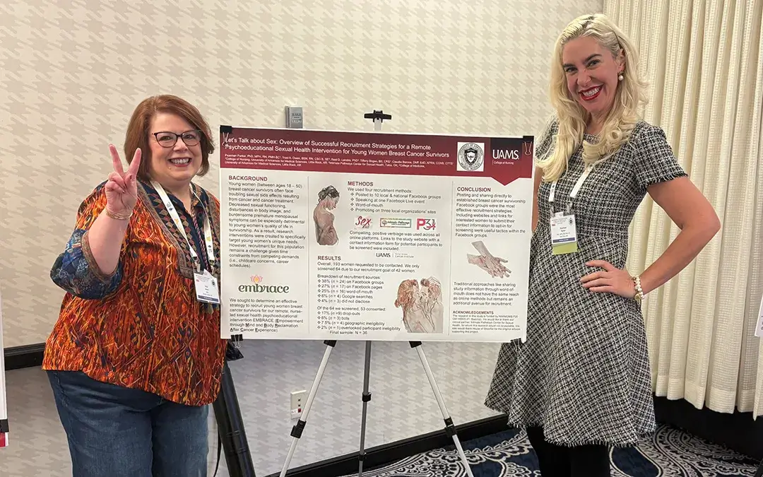 Traci and another speaker standing in front of a presentation board.